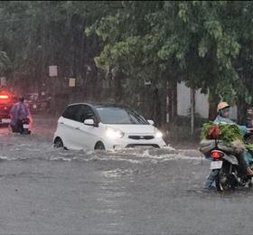 Hàng loạt người dân phải dắt bộ xe máy trên đường phố ngập nước ở Thanh Hoá